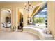 Bright living room with a window seat overlooking the pool, patio, and waterway beyond at 6143 9Th Avenue Ne Cir, Bradenton, FL 34212