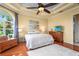 Primary bedroom with wood floors, ceiling fan, and dresser with TV at 6143 9Th Avenue Ne Cir, Bradenton, FL 34212