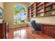 Home office with custom built-in shelving, a large window, and hardwood floors at 6143 9Th Avenue Ne Cir, Bradenton, FL 34212