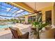 Exterior view of the covered patio with comfortable seating, fan, and enclosed pool area at 6143 9Th Avenue Ne Cir, Bradenton, FL 34212
