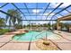 Enclosed pool with tropical landscape, lake view and brick patio at 6143 9Th Avenue Ne Cir, Bradenton, FL 34212