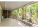 Spacious tiled screened-in patio surrounded by green, tropical foliage and wood fence at 642 N Jefferson Ave # 13, Sarasota, FL 34237