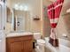 Cozy bathroom with wood cabinets, a shower with a bathtub, and warm lighting at 7346 Skybird Rd # 417, Bradenton, FL 34209