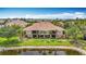 Rear exterior view of condo building overlooking a pond with lush landscaping and screened-in lanais at 7346 Skybird Rd # 417, Bradenton, FL 34209