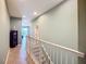 Hallway shows open railing, light green walls, tile floors, and a glimpse into the living area in neutral tones at 7346 Skybird Rd # 417, Bradenton, FL 34209