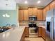 Bright kitchen features stainless steel appliances, wooden cabinetry, and neutral-toned countertops, offering a modern feel at 7346 Skybird Rd # 417, Bradenton, FL 34209