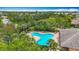 Aerial view of community pool area surrounded by palm trees and other verdant landscaping at 7346 Skybird Rd # 417, Bradenton, FL 34209