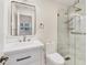 Modern bathroom with a glass-enclosed shower, sleek vanity, large mirror, and fixtures create a clean and luxurious design at 7551 Calle Facil, Sarasota, FL 34238