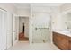 Bright bathroom featuring a glass shower with pebble floor, double doors, and white cabinets, creating a clean and modern feel at 7551 Calle Facil, Sarasota, FL 34238