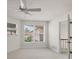 A bright room with a ceiling fan and two windows with blinds looking out on greenery at 7551 Calle Facil, Sarasota, FL 34238