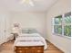 Bright bedroom featuring a window, light-colored walls, wood floor, and neutral decor, creating a serene and inviting space at 7551 Calle Facil, Sarasota, FL 34238