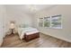 Cozy bedroom with light wood floors, a bright window, a ceiling fan, and charming decor creating a relaxing atmosphere at 7551 Calle Facil, Sarasota, FL 34238