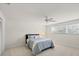 Spacious bedroom with light carpet, a window, and a ceiling fan creates a serene and airy atmosphere at 7551 Calle Facil, Sarasota, FL 34238