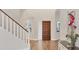 Welcoming foyer featuring hardwood floors, a staircase, and a wooden front door at 7551 Calle Facil, Sarasota, FL 34238