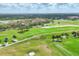 Aerial view of a beautiful golf course with palm trees and lush fairways, set within a picturesque residential community at 7551 Calle Facil, Sarasota, FL 34238