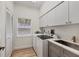 Well-lit laundry room with modern appliances, ample storage, and a sink at 7551 Calle Facil, Sarasota, FL 34238