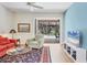 Comfortable living room with views of the pool, a cozy chair, and a modern television at 7551 Calle Facil, Sarasota, FL 34238