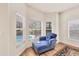 Sitting area in the main bedroom with views of the pool and a cozy blue chaise lounge at 7551 Calle Facil, Sarasota, FL 34238