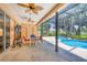 Relaxing screened-in patio with seating, a ceiling fan, and a pool/hot tub area with a golf course view at 7551 Calle Facil, Sarasota, FL 34238