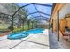 Spacious screened-in pool area with a hot tub and views of the surrounding greenery at 7551 Calle Facil, Sarasota, FL 34238