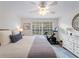 Inviting bedroom featuring a queen-size bed, ceiling fan, and exercise bike near a sunlit window at 7641 Quinto Dr, Sarasota, FL 34238