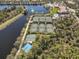 Aerial view features community pools, tennis courts, basketball court and a scenic lake with fountain at 7641 Quinto Dr, Sarasota, FL 34238