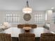 Dining room with stylish chandelier and decorative wall art, complementing the wicker chairs and spacious table at 7641 Quinto Dr, Sarasota, FL 34238