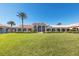 Beautiful building with arched windows, a manicured lawn, and palm trees at 7641 Quinto Dr, Sarasota, FL 34238