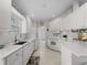 Clean and bright kitchen featuring white cabinets, stainless steel sink, and modern appliances for cooking convenience at 7641 Quinto Dr, Sarasota, FL 34238