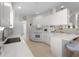 Bright kitchen with white cabinetry, modern appliances, and a breakfast bar overlooking the living area at 7641 Quinto Dr, Sarasota, FL 34238