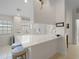 Well-lit kitchen featuring a breakfast bar, white cabinetry, and modern appliances for a seamless cooking experience at 7641 Quinto Dr, Sarasota, FL 34238