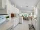 Bright kitchen with white cabinets, tile floors, and stainless appliances flowing into the dining and living areas at 7641 Quinto Dr, Sarasota, FL 34238