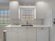 Bright kitchen featuring modern white cabinets, countertops and stainless steel dishwasher at 7641 Quinto Dr, Sarasota, FL 34238