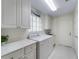 Well-lit laundry room featuring a washer, dryer, and ample cabinet space at 7641 Quinto Dr, Sarasota, FL 34238