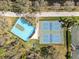 Aerial view of sports courts include basketball and pickleball near lake and trees at 7641 Quinto Dr, Sarasota, FL 34238