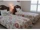 Charming bedroom with two twin beds, complemented by floral bedding, mermaid pillows and bright lamps at 802 Montrose Dr # 204, Venice, FL 34293