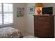 Cozy bedroom featuring bright natural light, tropical decor, and dresser with TV at 802 Montrose Dr # 204, Venice, FL 34293