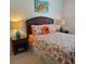 Stylishly decorated bedroom with a floral comforter, unique headboard, and contemporary lamps at 802 Montrose Dr # 204, Venice, FL 34293