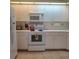 Kitchen with white cabinetry, appliances, and tiled backsplash at 802 Montrose Dr # 204, Venice, FL 34293