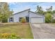 Light blue single Gathering home features an attached two-car garage and xeriscaped front yard at 8160 Glenbrooke Ct, Sarasota, FL 34234