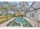 View of a screened lanai area with inground pool, spa, and french doors at 8160 Glenbrooke Ct, Sarasota, FL 34234