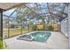 View of a screened lanai area with inground pool, spa, and lush landscaping at 8160 Glenbrooke Ct, Sarasota, FL 34234