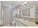 Bathroom features a shower with curtain, vanity, large mirror, and convenient storage at 9366 Westminster Ave, Englewood, FL 34224