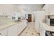 Bright kitchen featuring white cabinets, tile backsplash, and ample counter space for cooking and entertaining at 9366 Westminster Ave, Englewood, FL 34224