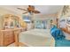 Bright main bedroom features a ceiling fan, neutral paint color, large window, and wood furniture at 9366 Westminster Ave, Englewood, FL 34224