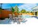 Outdoor patio with table and seating offers views of the pool and tropical landscaping at 1010 68Th Nw St, Bradenton, FL 34209