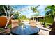 Backyard dining area overlooks the pool and lush tropical plants, creating a private oasis at 1010 68Th Nw St, Bradenton, FL 34209