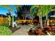 Outdoor dining set on stone patio perfect for enjoying meals in a beautifully landscaped backyard at twilight at 1010 68Th Nw St, Bradenton, FL 34209