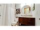 Bathroom featuring granite countertop sink, round mirror, and decorative shelving with a shower at 1010 68Th Nw St, Bradenton, FL 34209