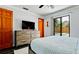 Bright bedroom featuring wood dresser, flat screen tv, ceiling fan, and access to the outdoor pool at 1010 68Th Nw St, Bradenton, FL 34209